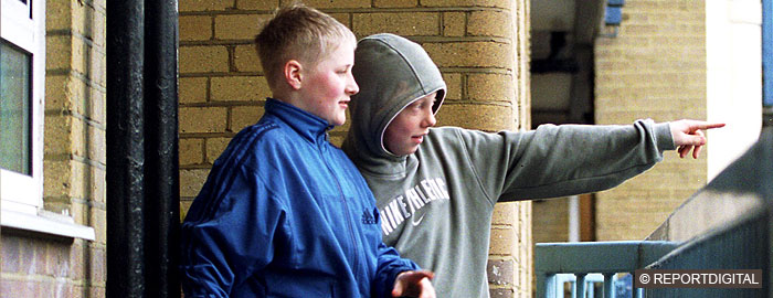 Two young white boys on flats walkway, one pointing